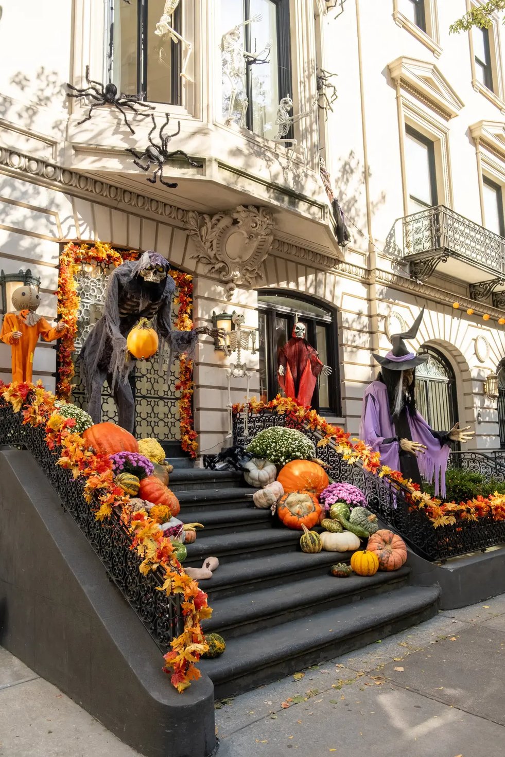 Halloween-themed brownstone decorated with spooky figures on the stairs.