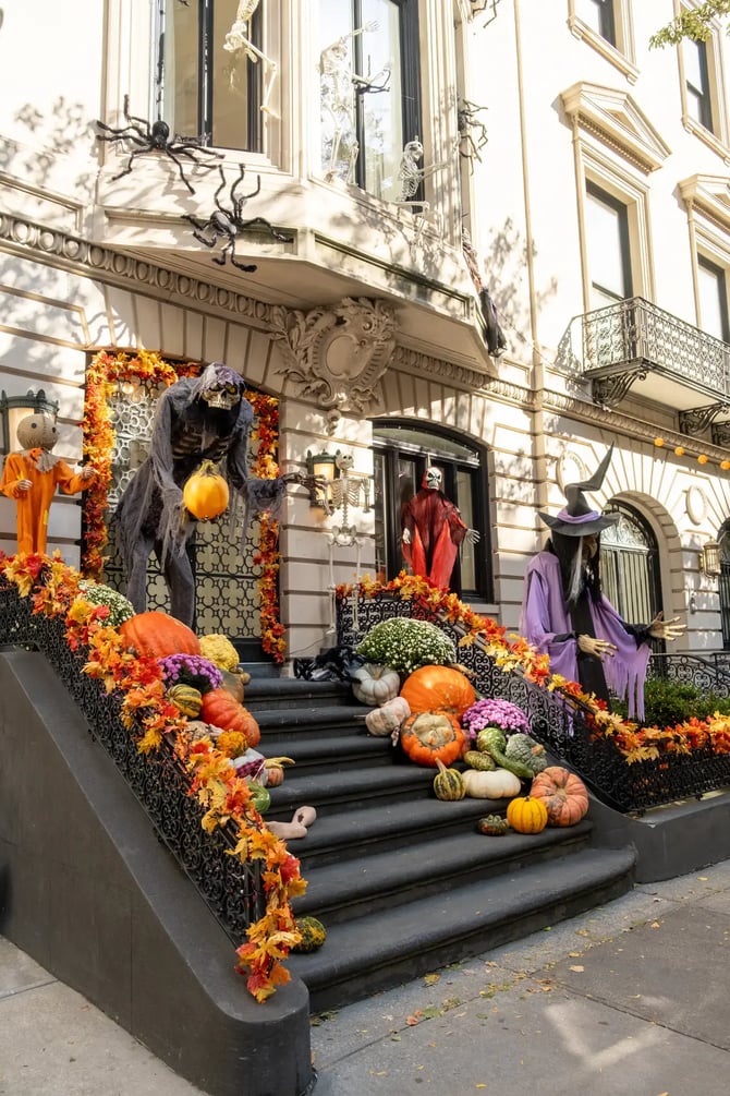 Halloween-themed brownstone decorated with spooky figures on the stairs.