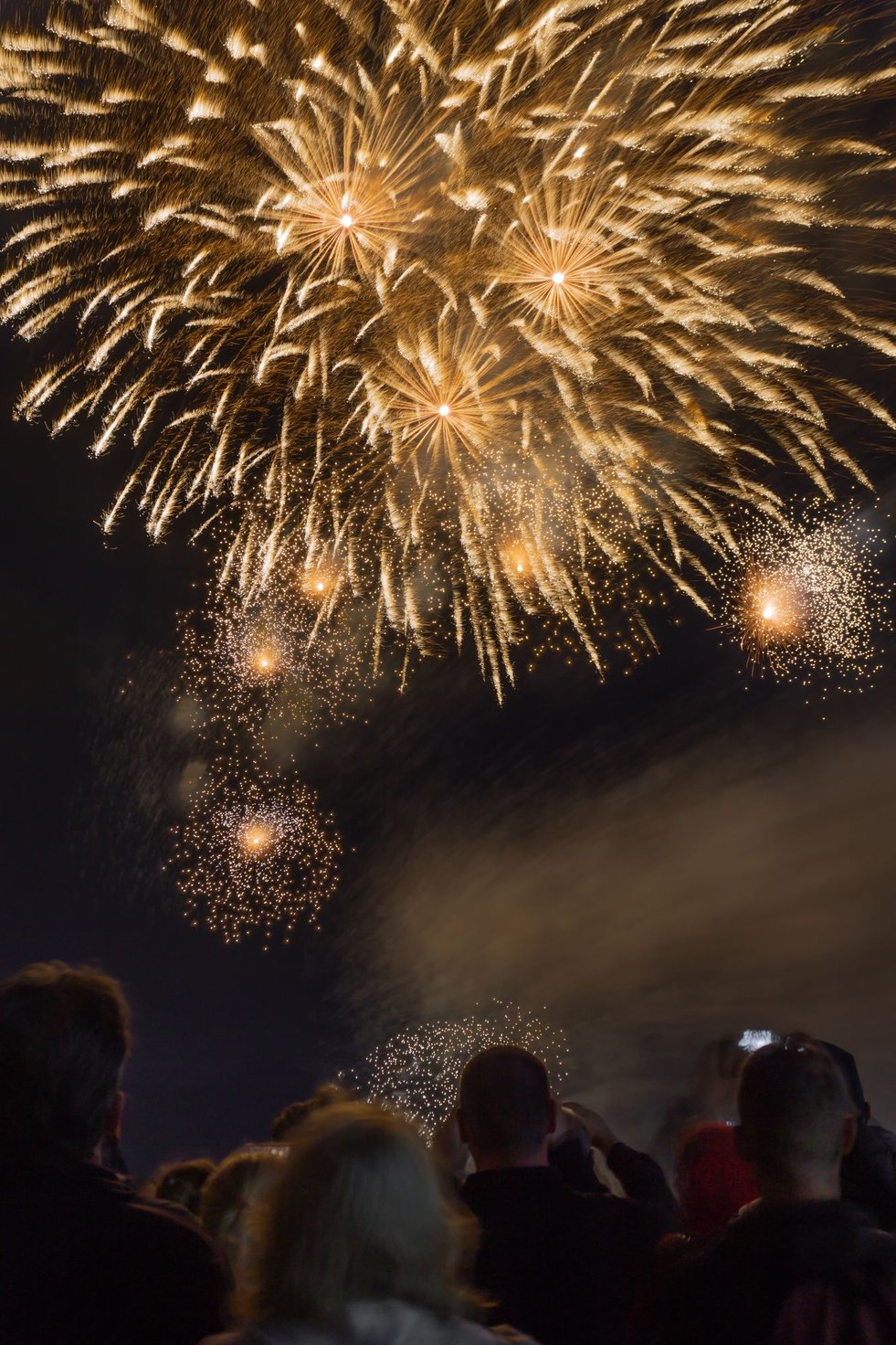 People celebrating New Year’s Eve at a rooftop party overlooking NYC’s skyline.