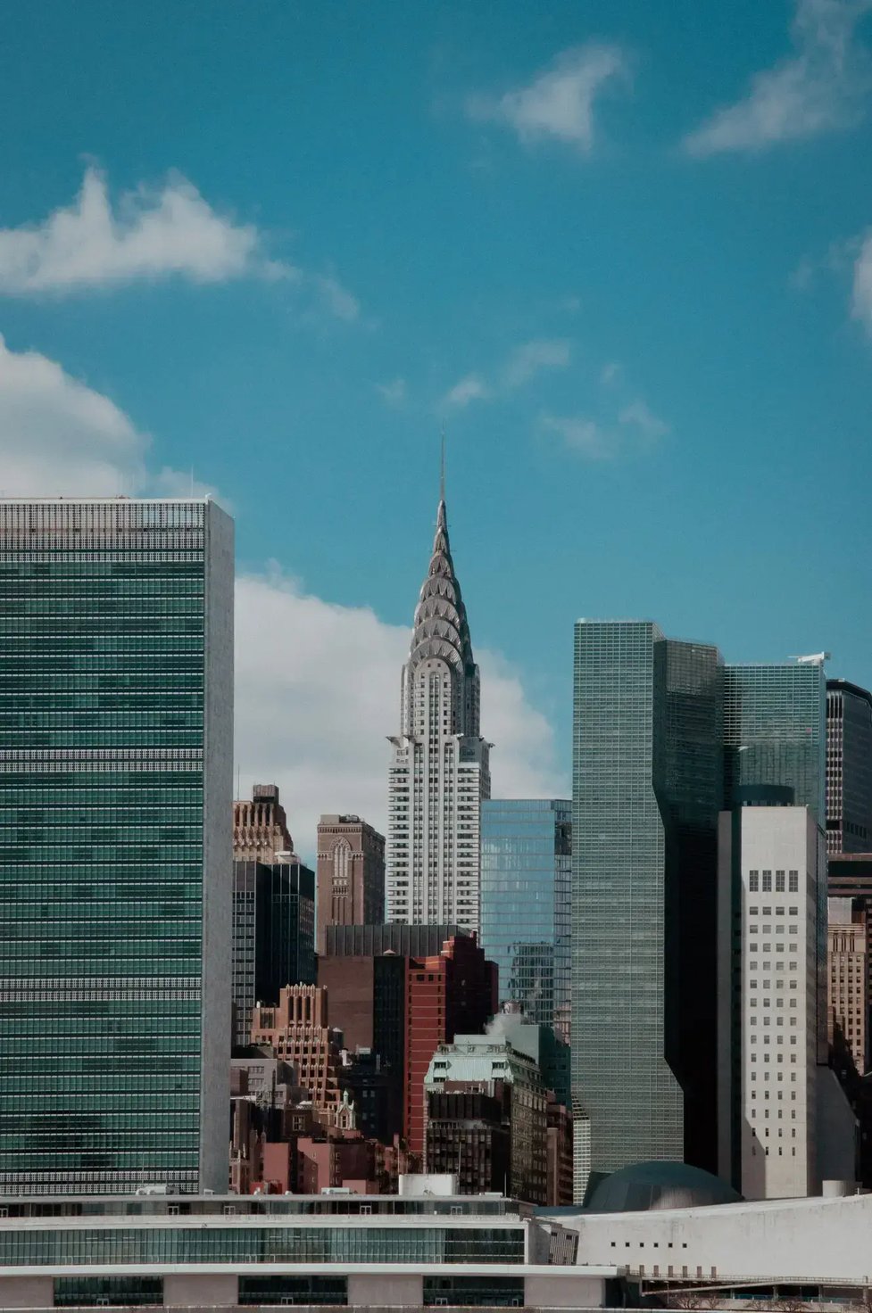 Magnificent view of the New York City skyline under a clear blue sky, featuring the Chrysler Building and its modern architecture