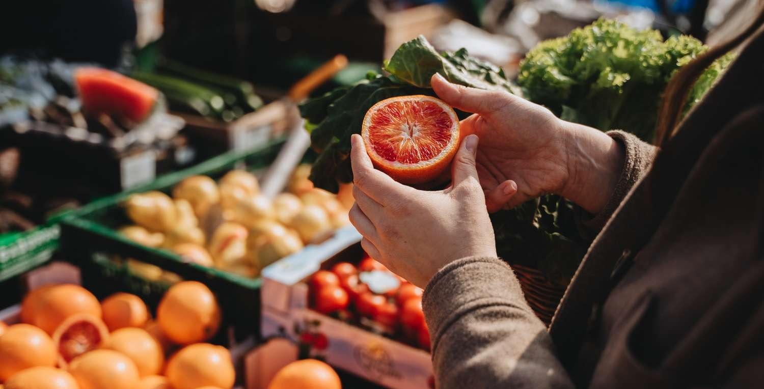 A person buying grapefruit in Chelsea Market