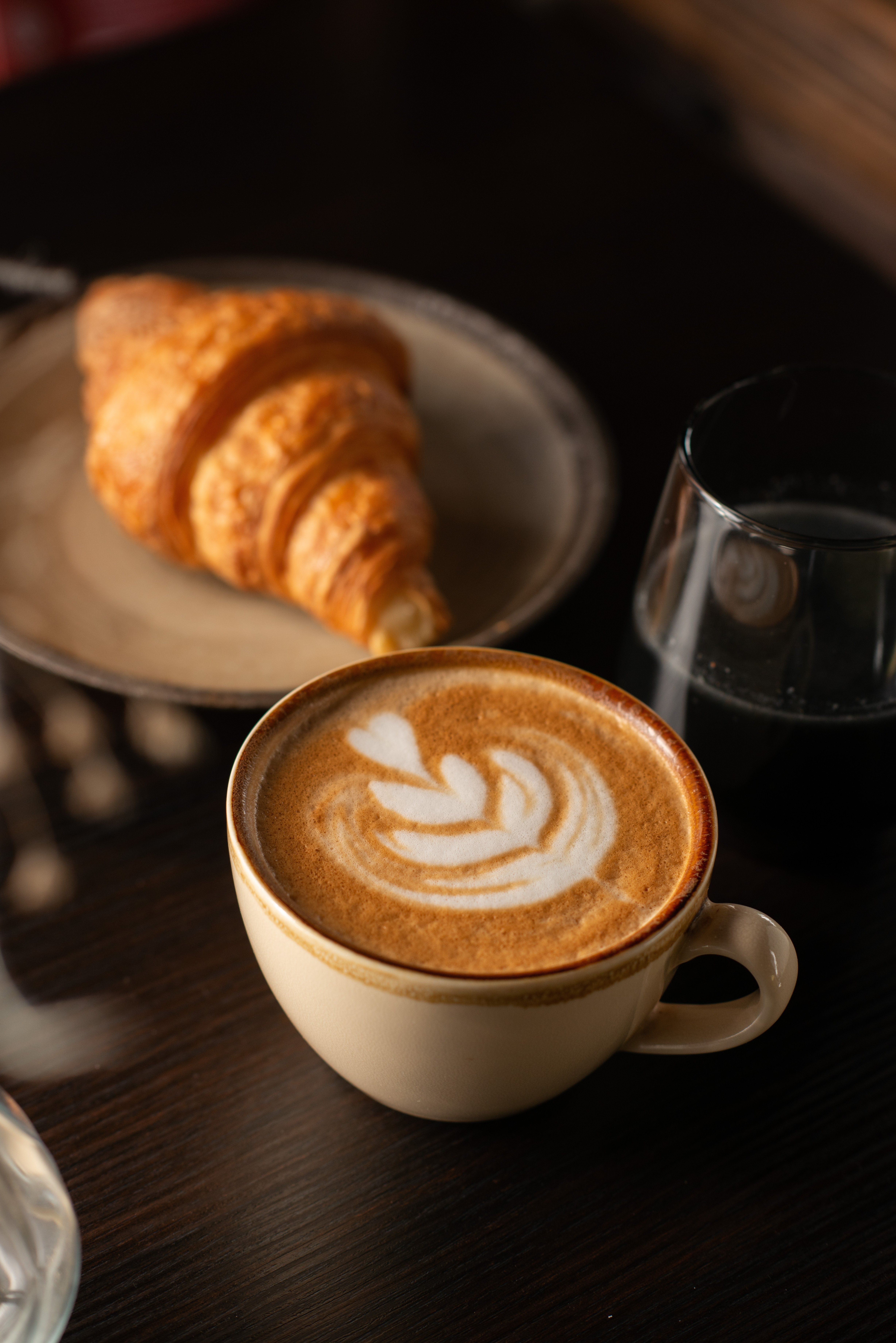 A cup of coffee with a croissant, image by Simone Oppes